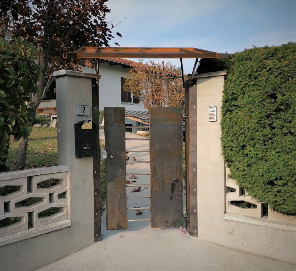cancello pedonale in Corten e sbarre in acciaio inox con pensilina